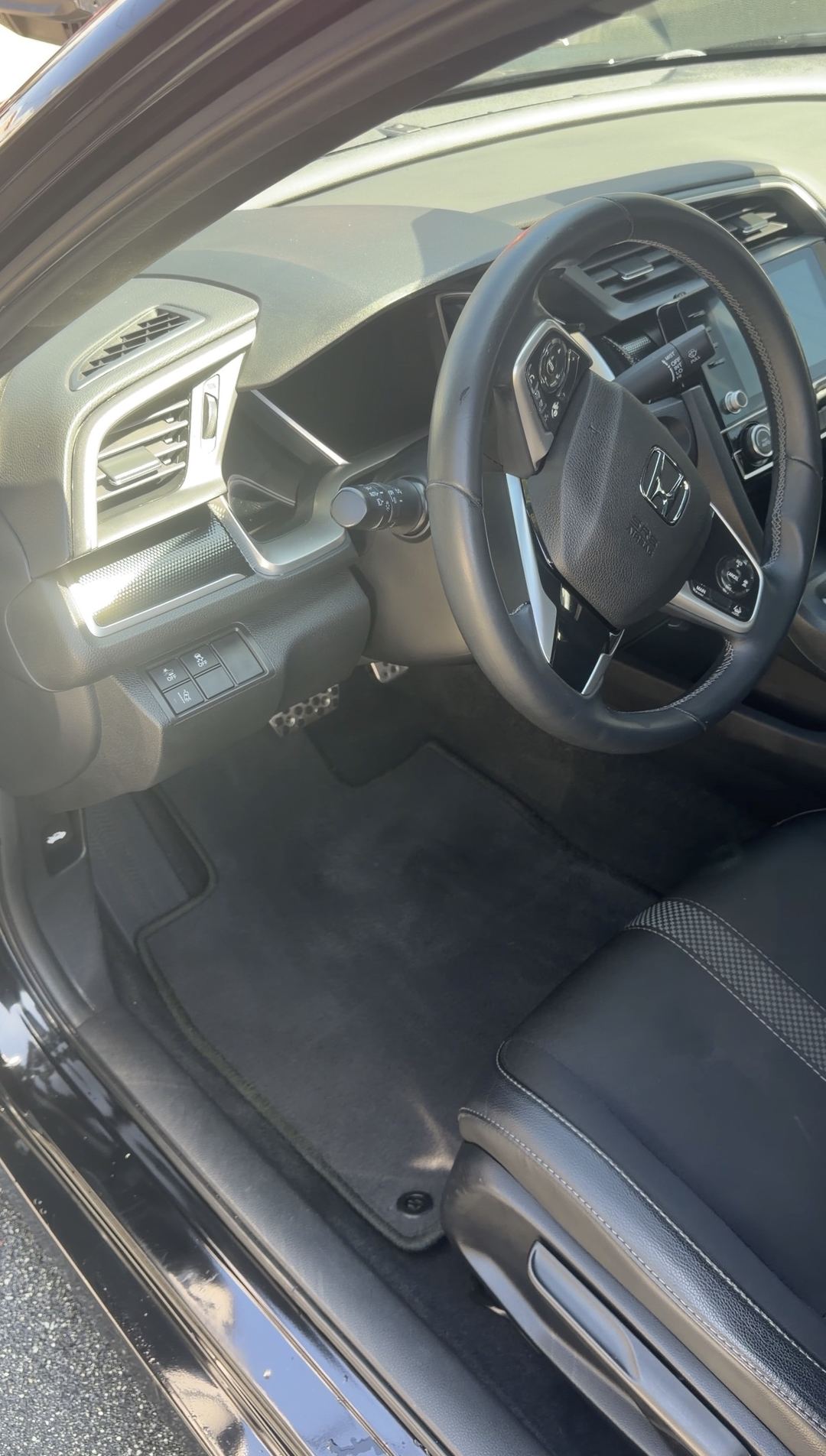 Clean driver floor mat and cockpit of a Honda Civic after the interior detail