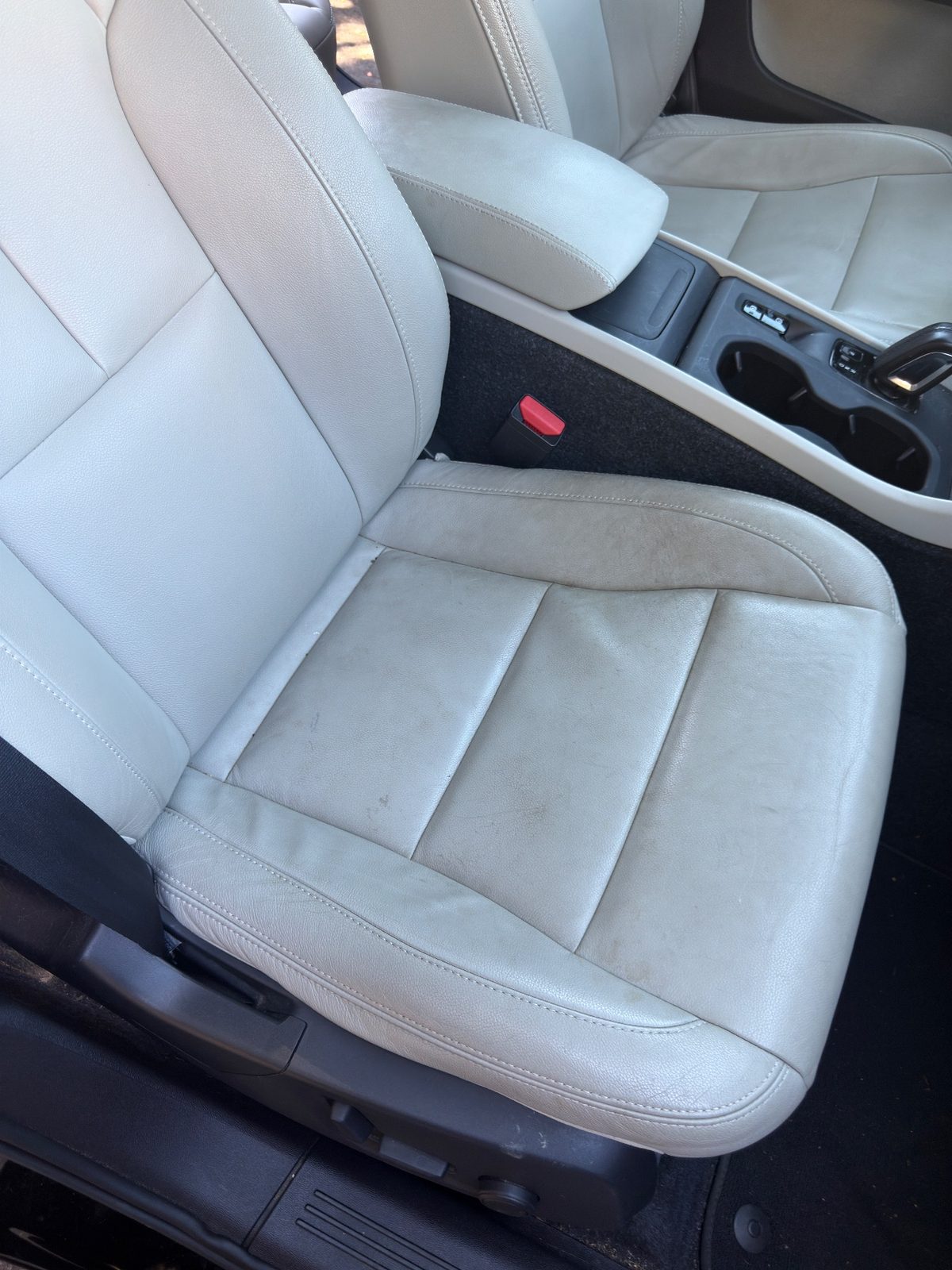 Front passenger leather seat of a Volvo XC40 with yellow-brown soiling and grime before detailing