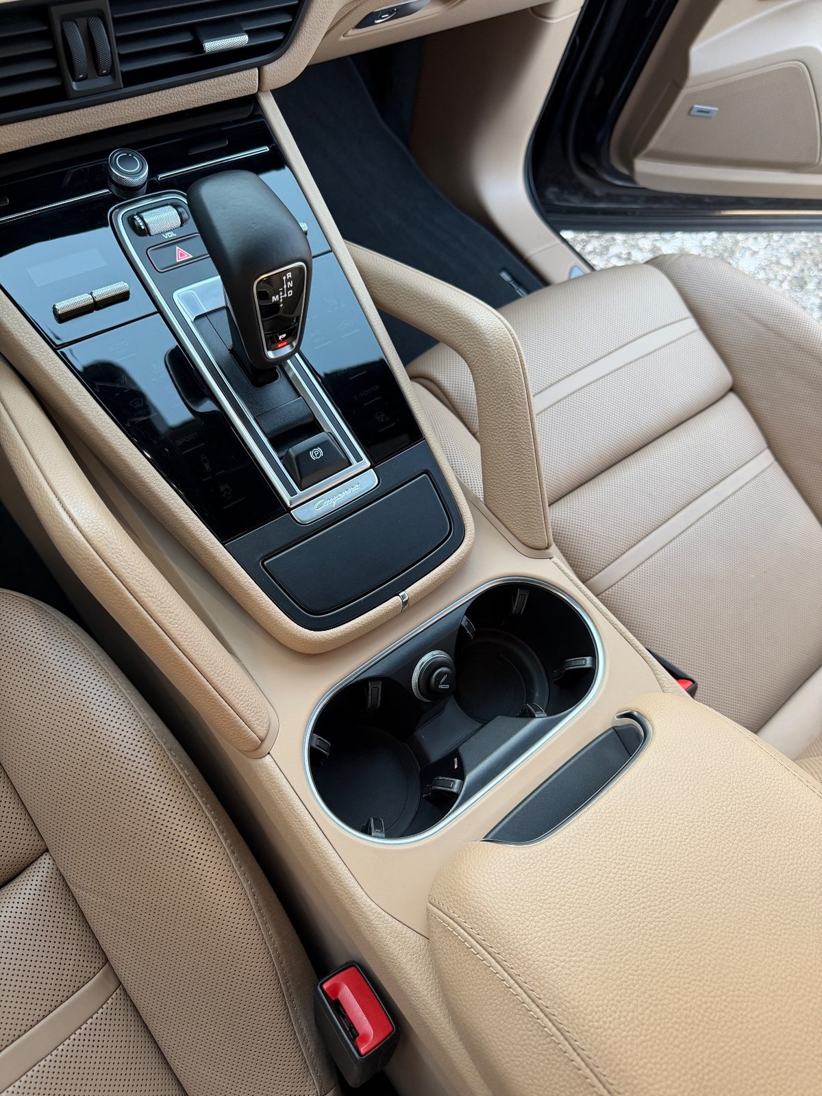 Clean centre console of a Porsche Cayenne after detailing, gloss trim and cupholders spotless