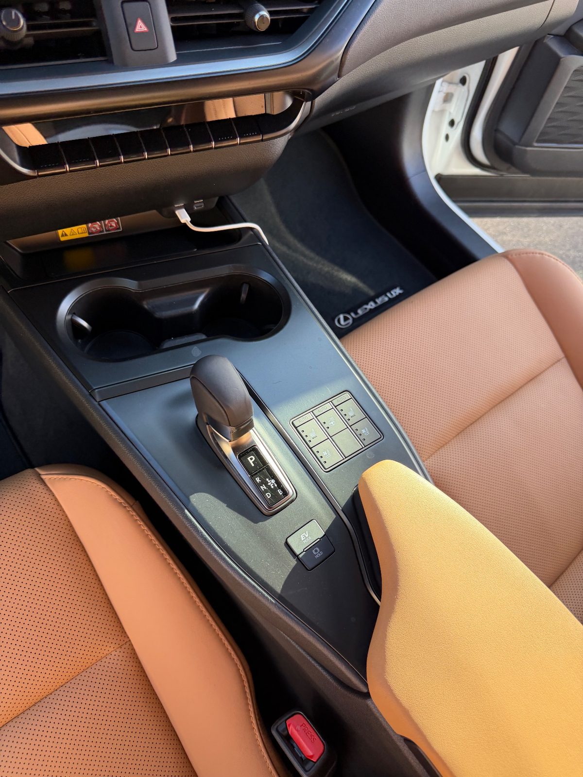 Clean centre console and shifter of a white Lexus UX hybrid after detailing