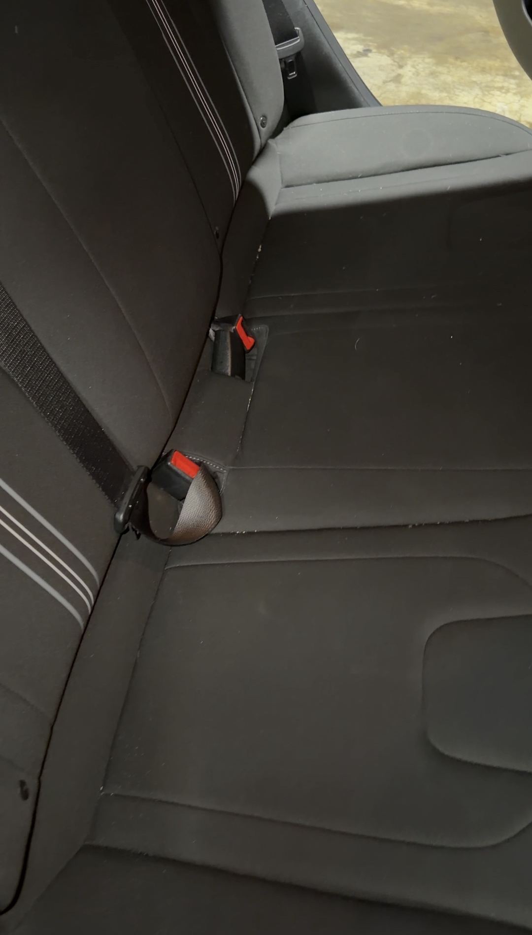 Rear seat cushion of a Hyundai Elantra with lint in the crease before cleaning