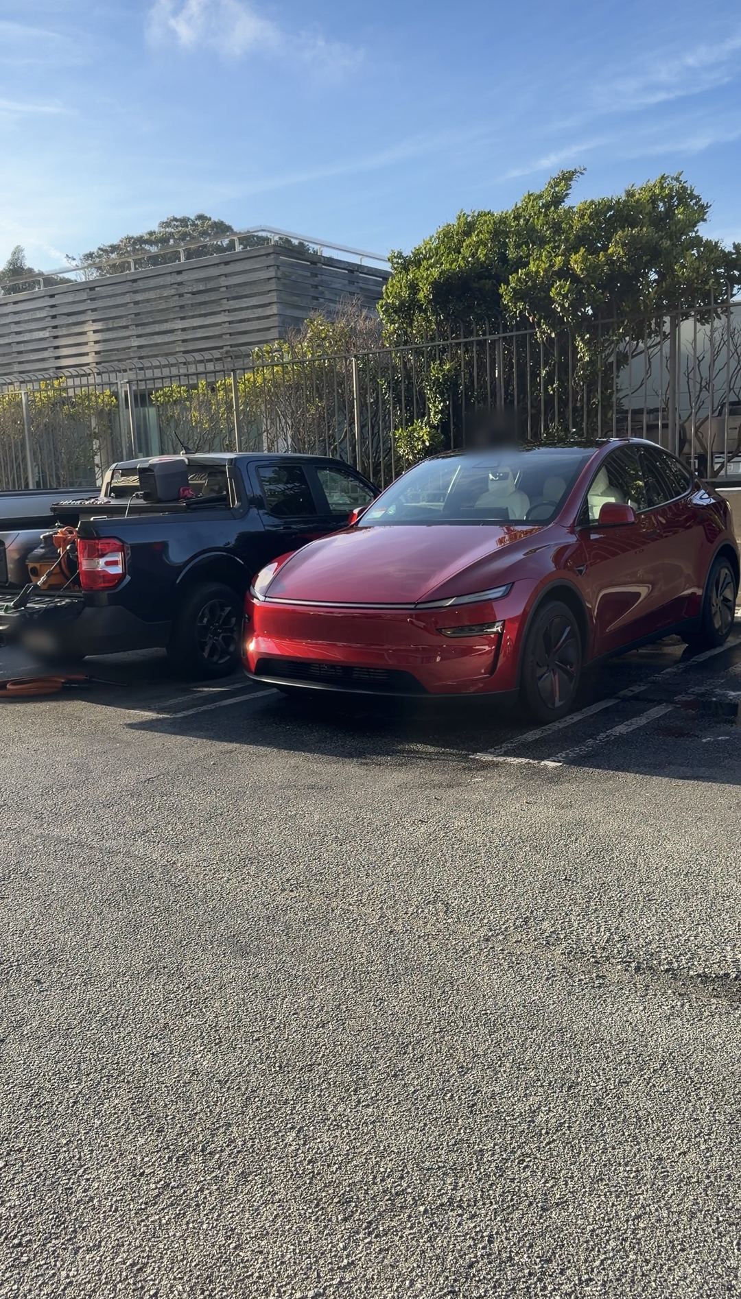 Freshly detailed red Tesla Model Y parked in a lot after an exterior detail