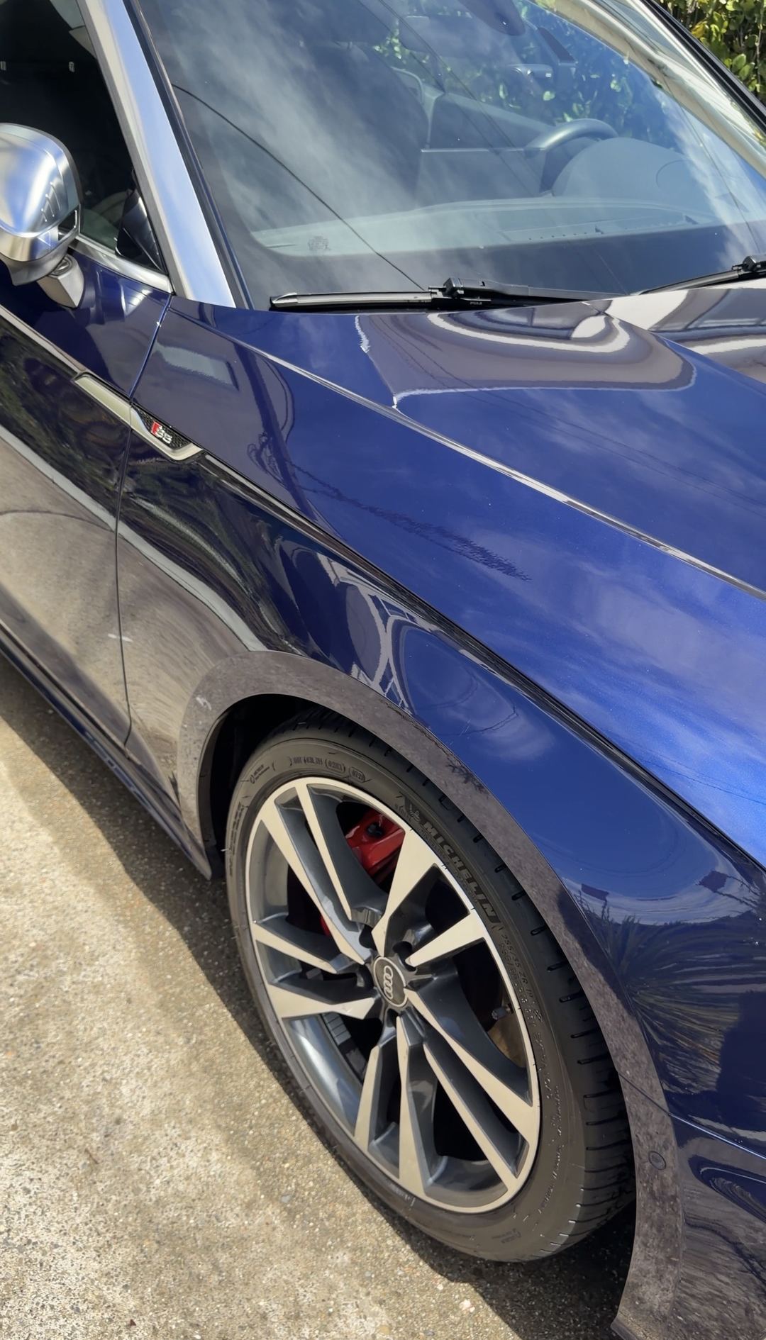 Front wheel with a red brake caliper and glossy blue fender of an Audi S5