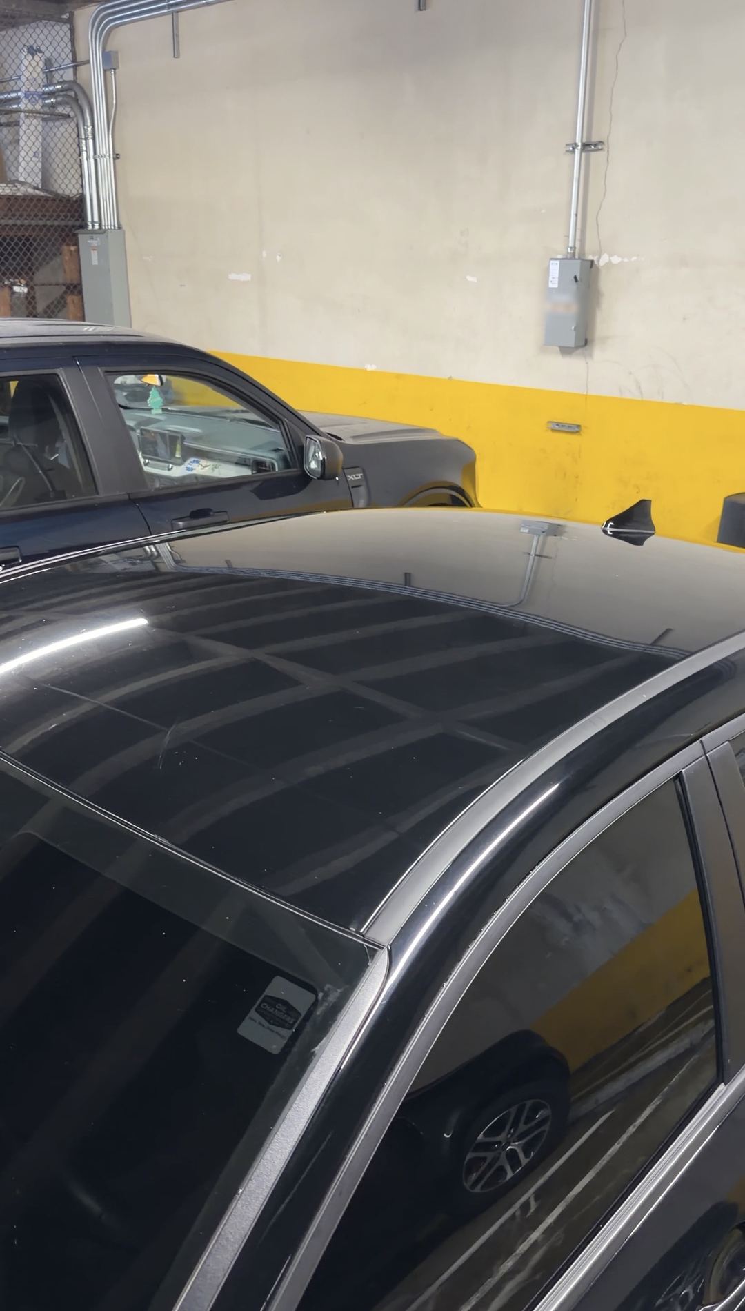 Glossy roof of a washed black Hyundai Elantra reflecting garage lights