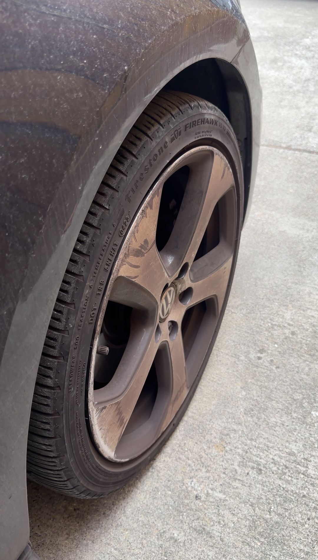 Front wheel of a black VW GTI coated in brake dust, Firestone Firehawk tyre