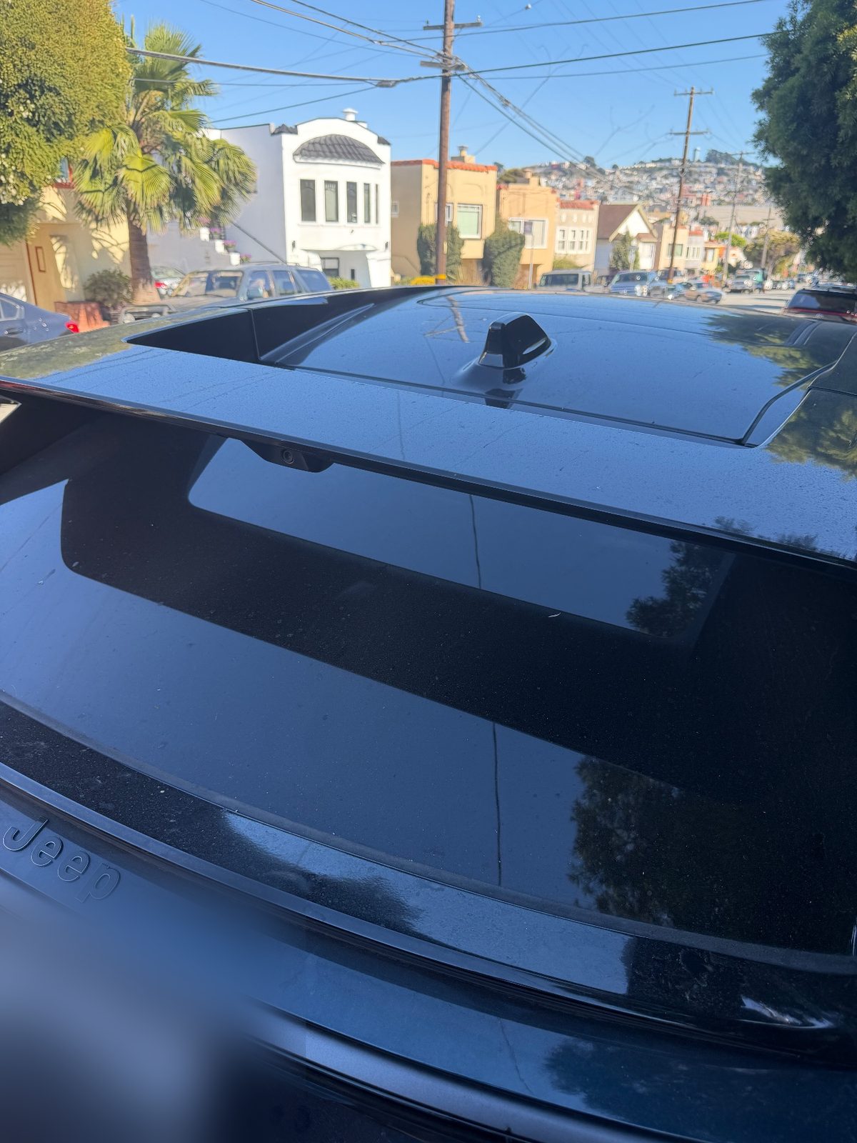 Rear glass and tailgate of a Jeep Wagoneer S before detailing, with dust and water spots