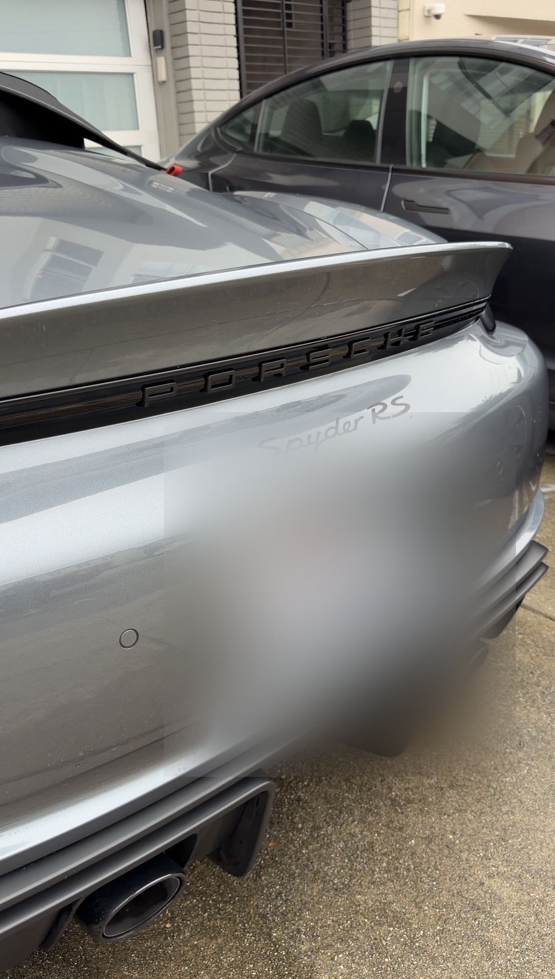 Rear of a clean grey Porsche 718 Spyder RS showing the Spyder RS script, ducktail spoiler and twin centre exhausts.