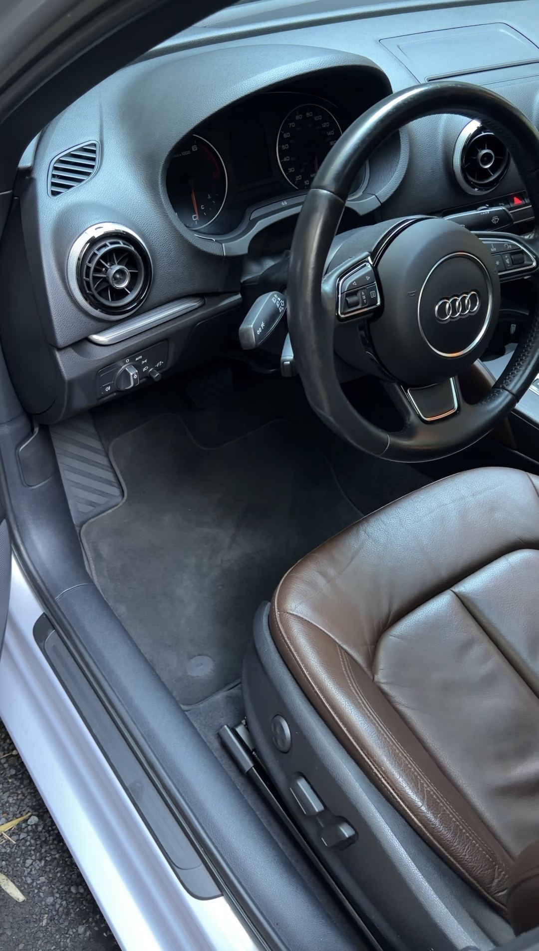 Clean driver footwell and cockpit of an Audi A3 with a brown leather seat