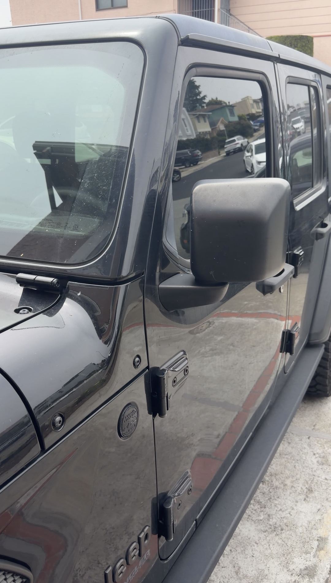 Black Jeep Wrangler front door and mirror with dust and water spots before an exterior detail