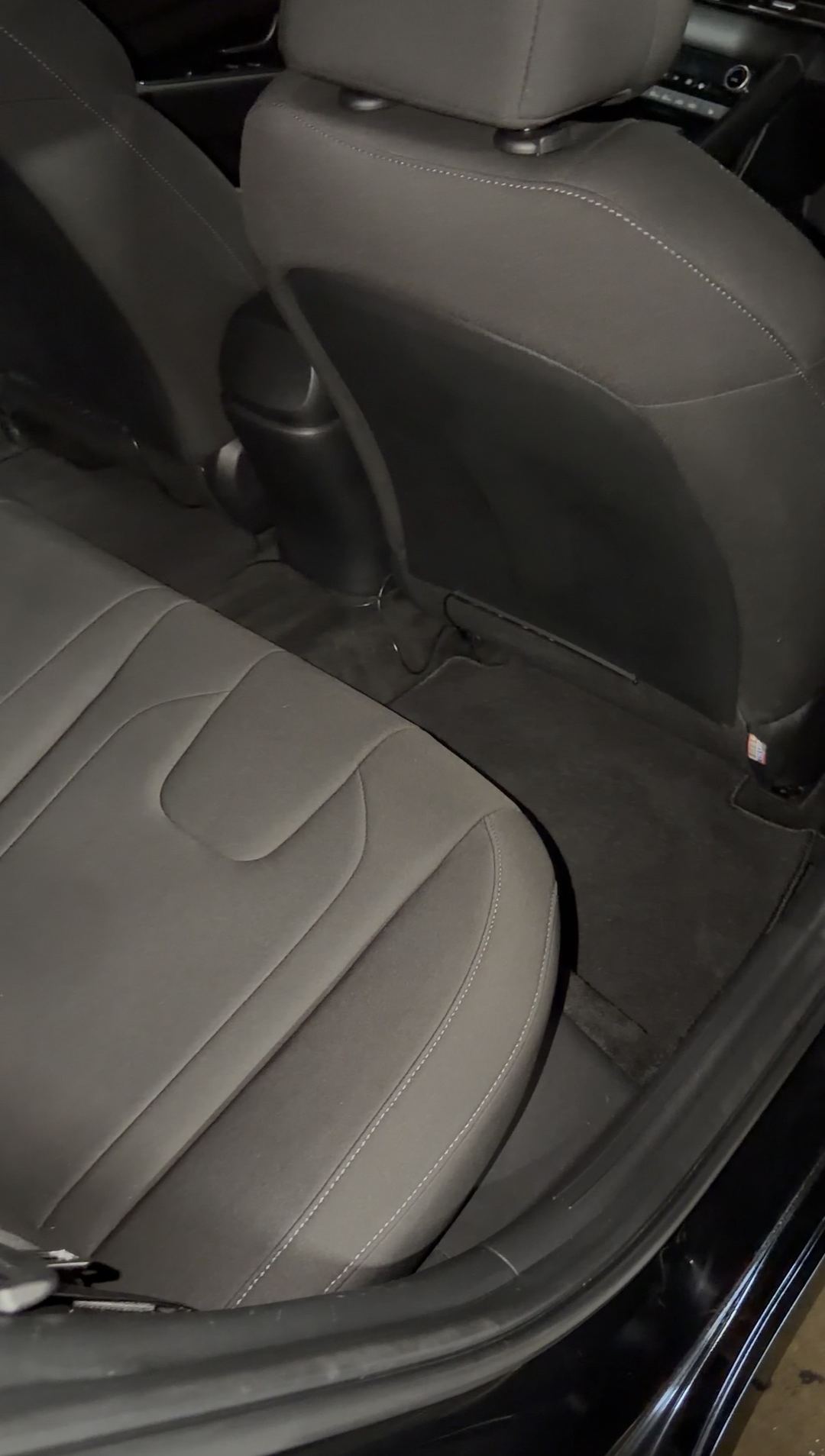 Clean rear footwell and floor mat behind the front seat of a Hyundai Elantra