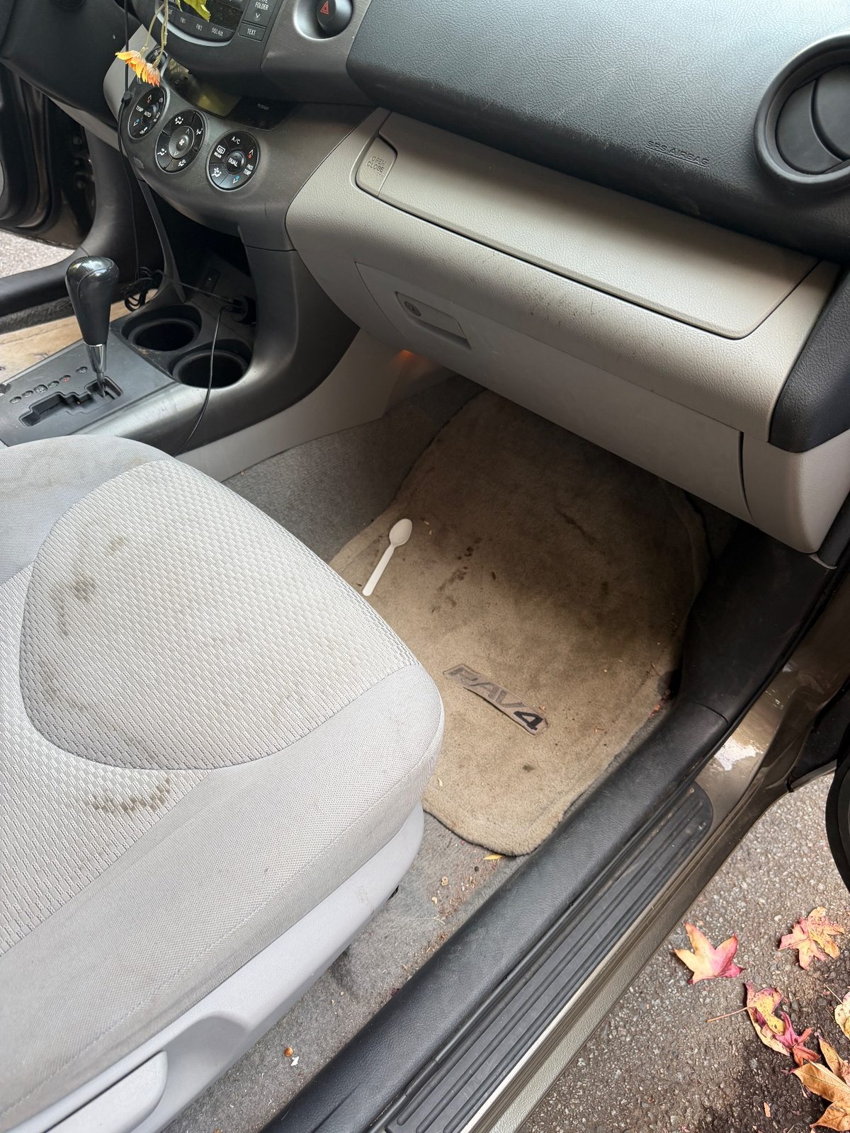 Front passenger footwell of a bronze Toyota RAV4 in the Inner Sunset, San Francisco, before detailing
