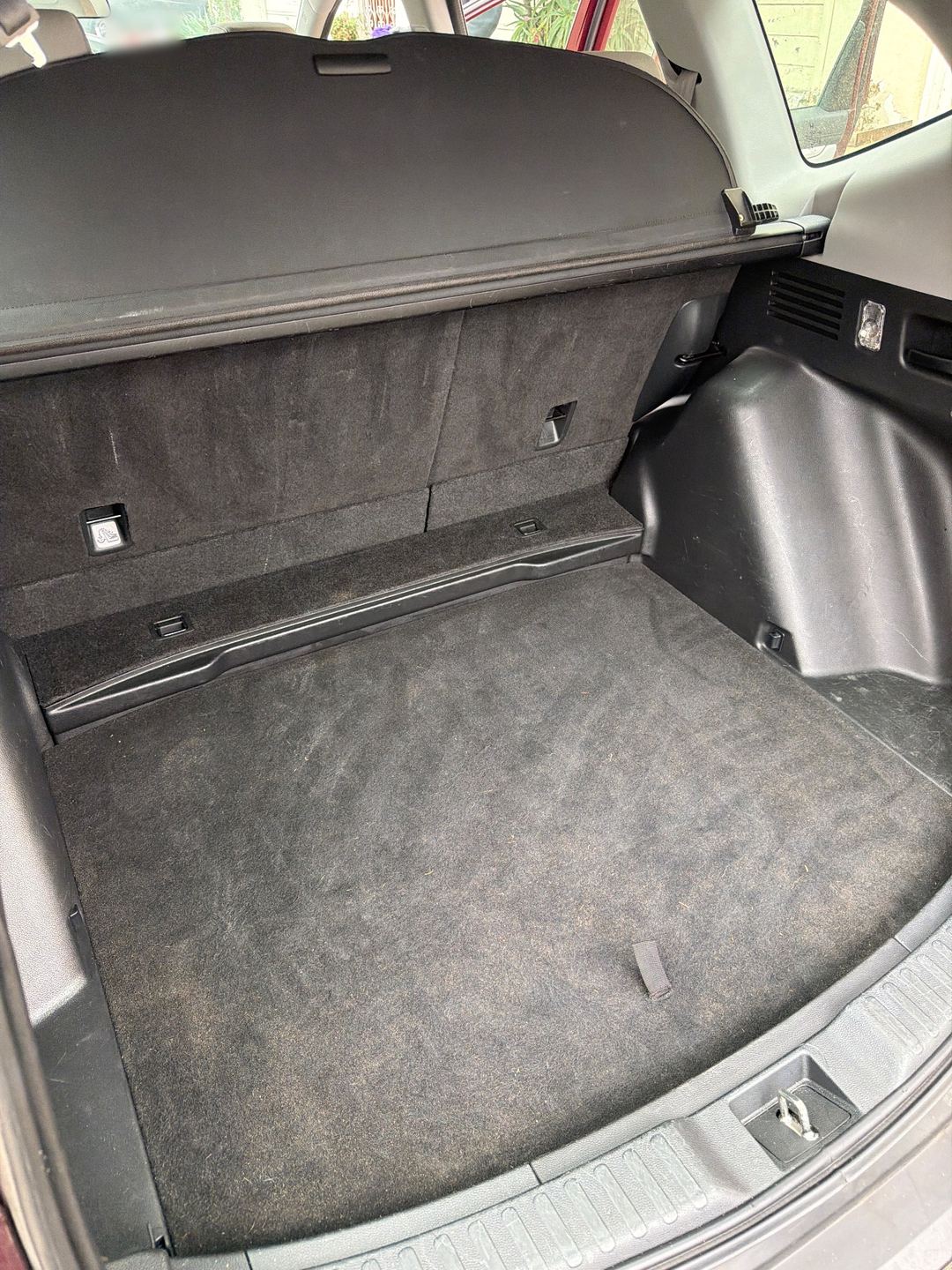 Cargo area of a maroon Honda CR-V after detailing, the carpet vacuumed clean