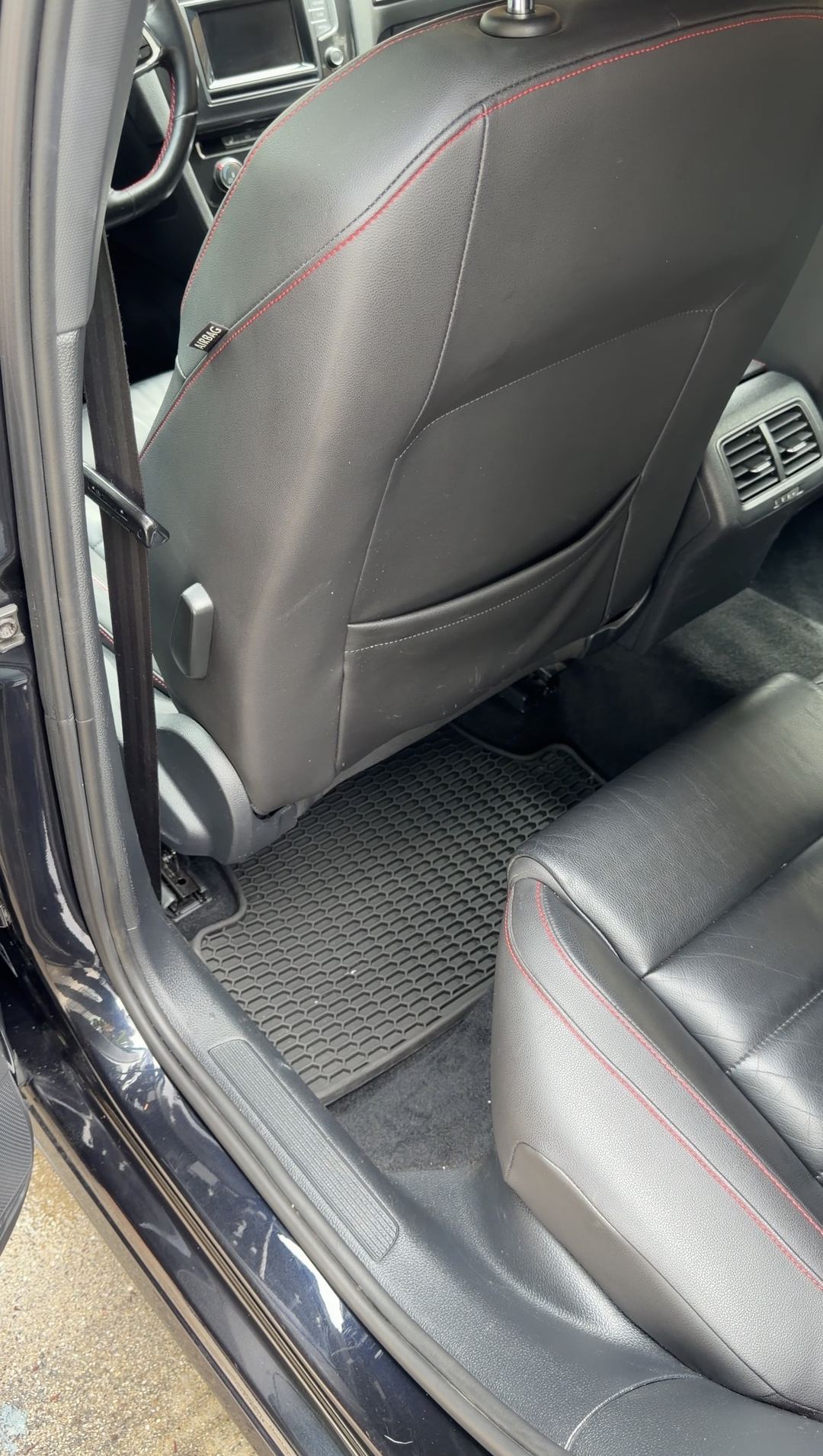 Rear footwell of a black VW GTI after cleaning, clean rubber mat and carpet