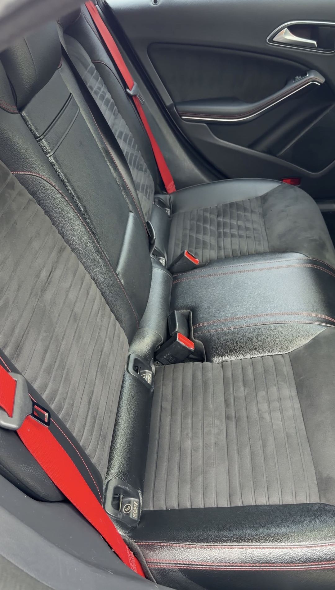Cleaned rear bench and door card of a Mercedes-Benz CLA250 with grey microfibre seats and red seatbelts