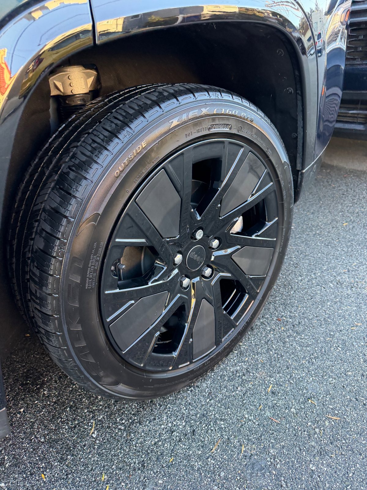 Clean gloss black wheel and dressed tyre on a Jeep Wagoneer S after detailing