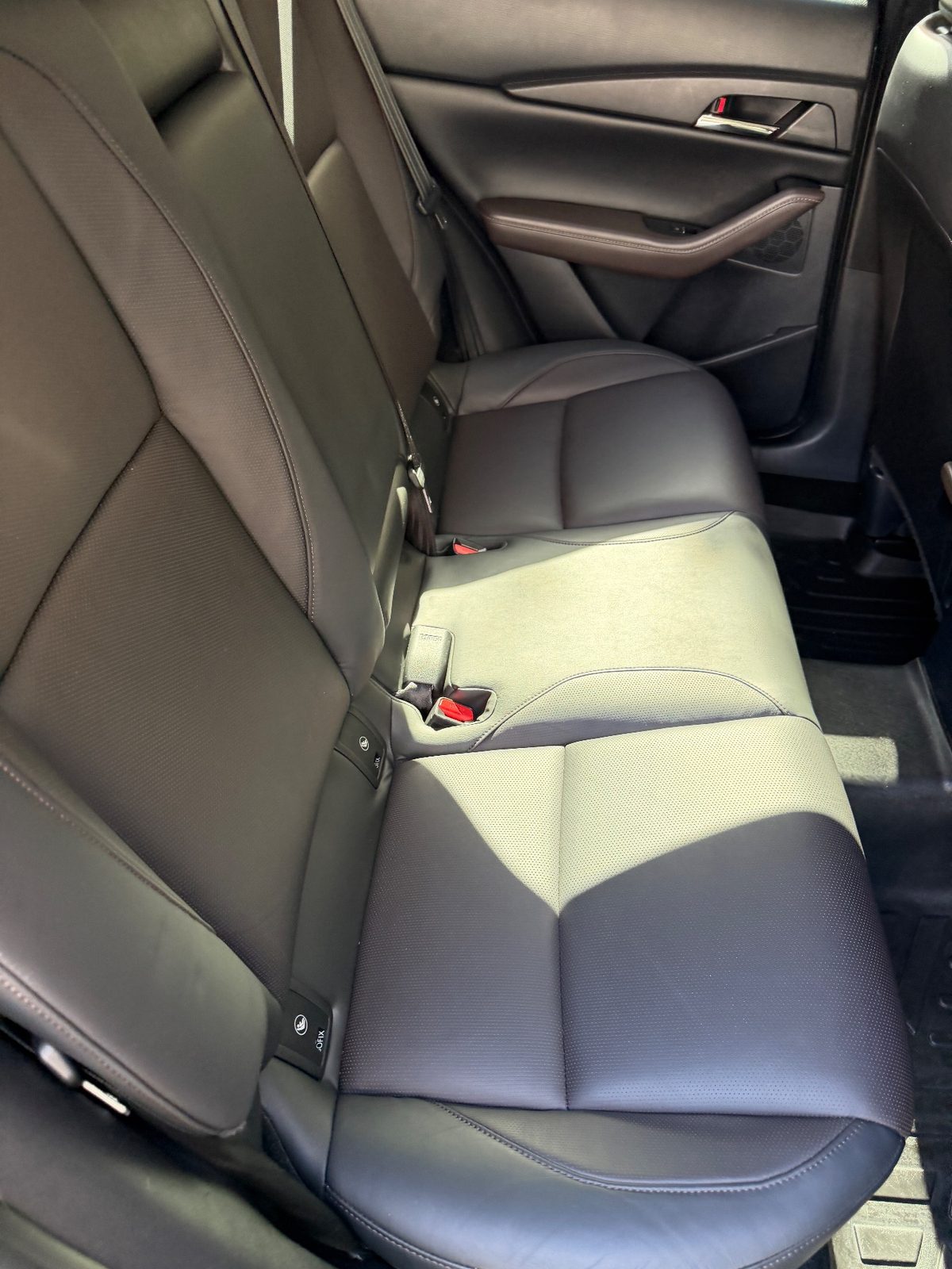 Rear bench of a grey Mazda CX-30 after detailing, clean leather in sunlight