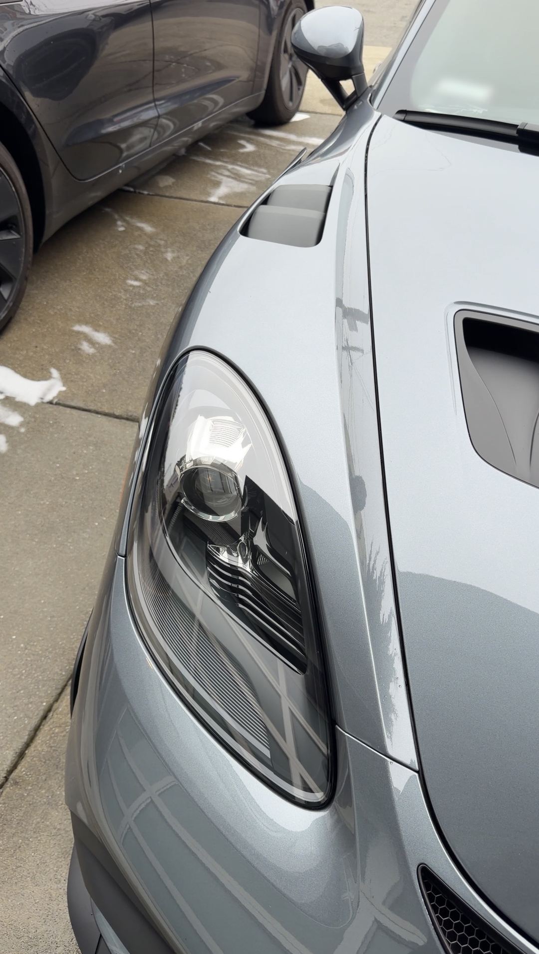 Clean headlight and bonnet duct of a grey Porsche 718 Spyder RS after a mobile detail.
