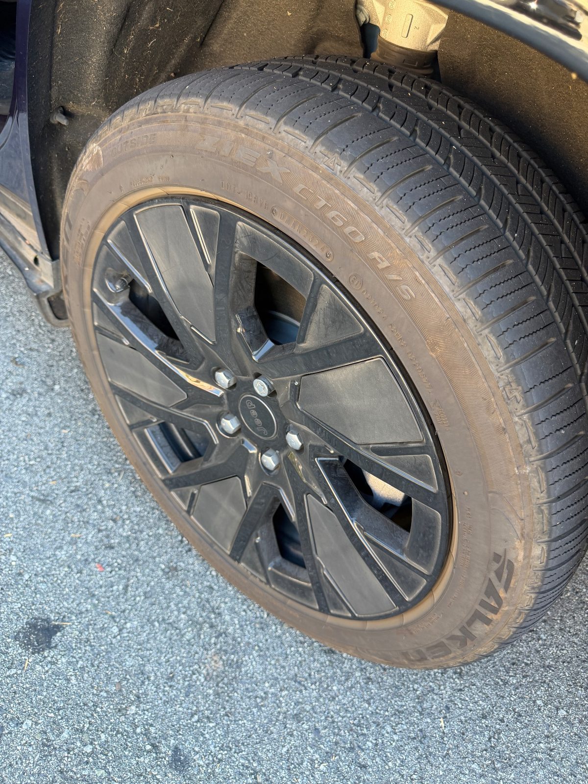 Dusty Falken tyre and gloss black Jeep wheel on a Wagoneer S before cleaning