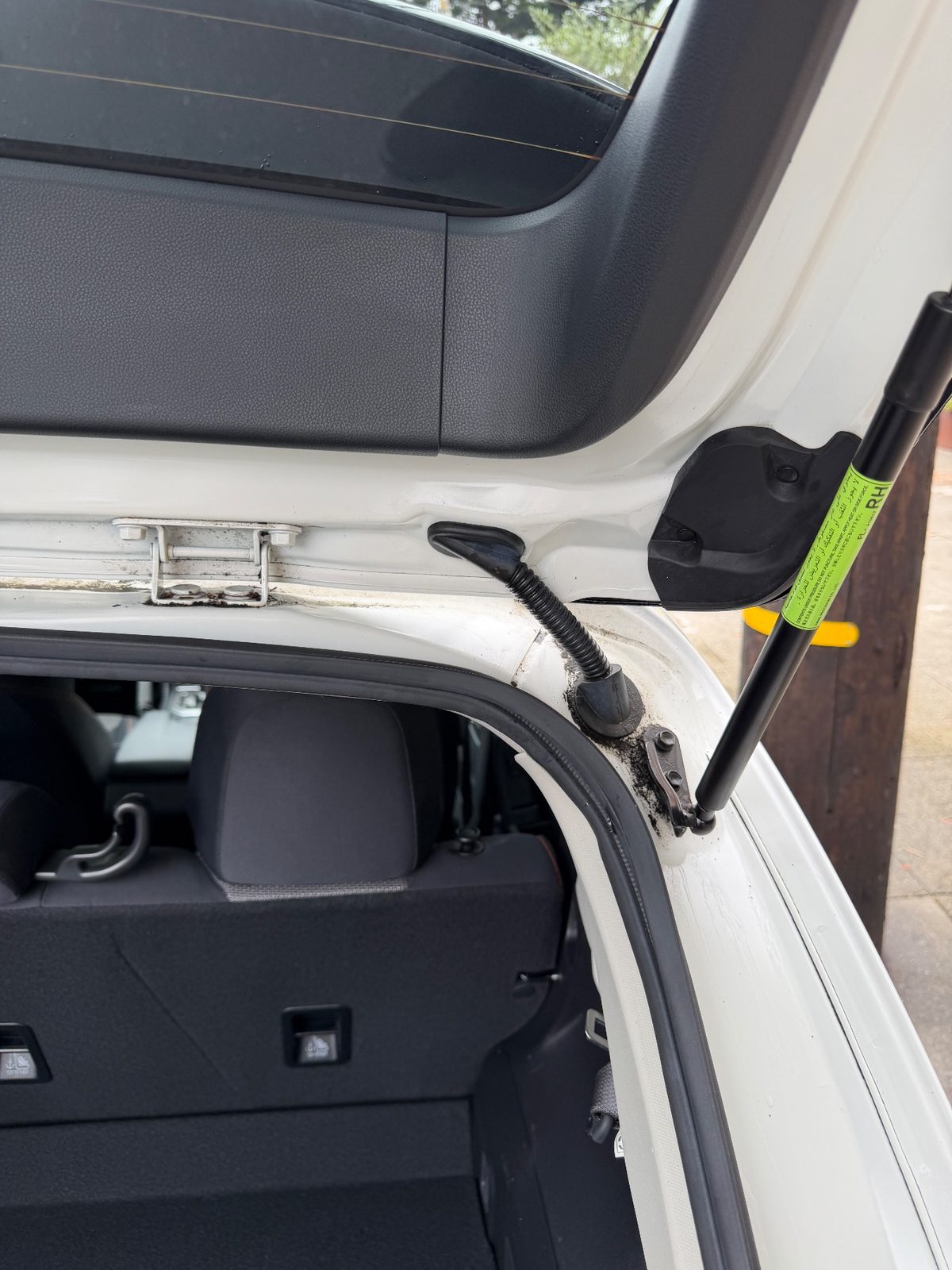 Right hatch strut and hinge gutter of a white Subaru Crosstrek in the Inner Richmond, San Francisco, after detailing