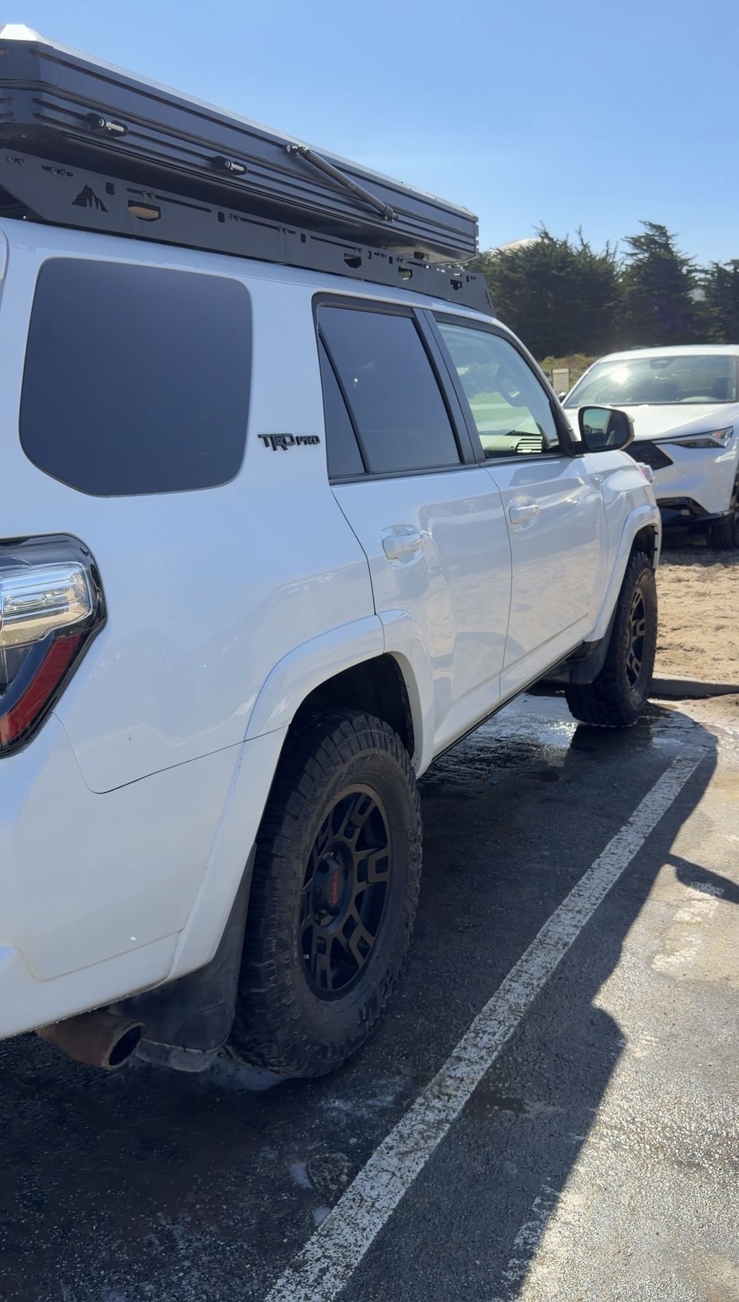 Passenger-side rear three-quarter view of a clean white Toyota 4Runner TRD Pro with black wheels