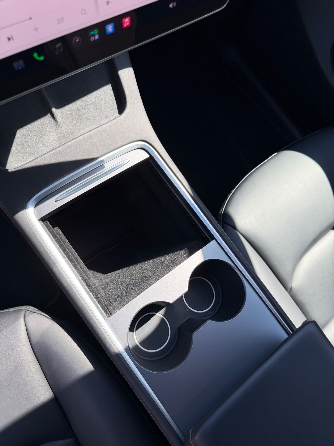 Clean centre console and cupholders of a Tesla Model Y after detailing