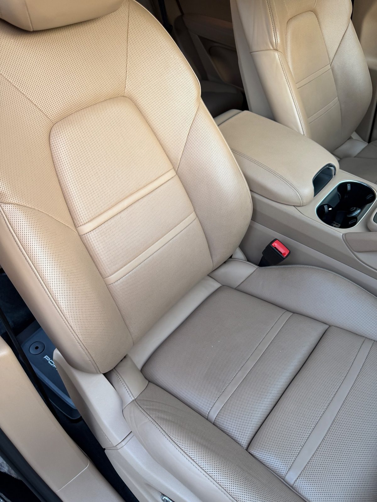 Clean passenger seat of a Porsche Cayenne after detailing, tan leather even and free of marks