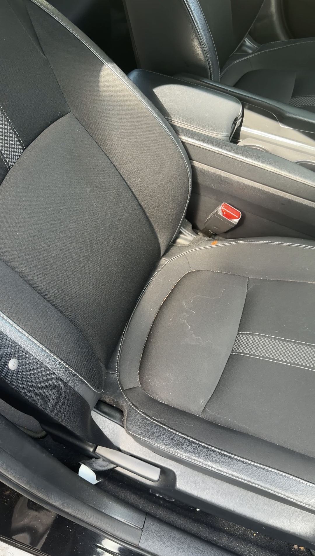 Stains on the cloth front passenger seat of a Honda Civic before cleaning