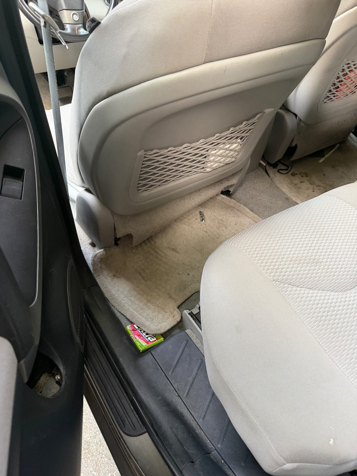 Rear driver-side footwell of a bronze Toyota RAV4 in the Inner Sunset, San Francisco, before detailing