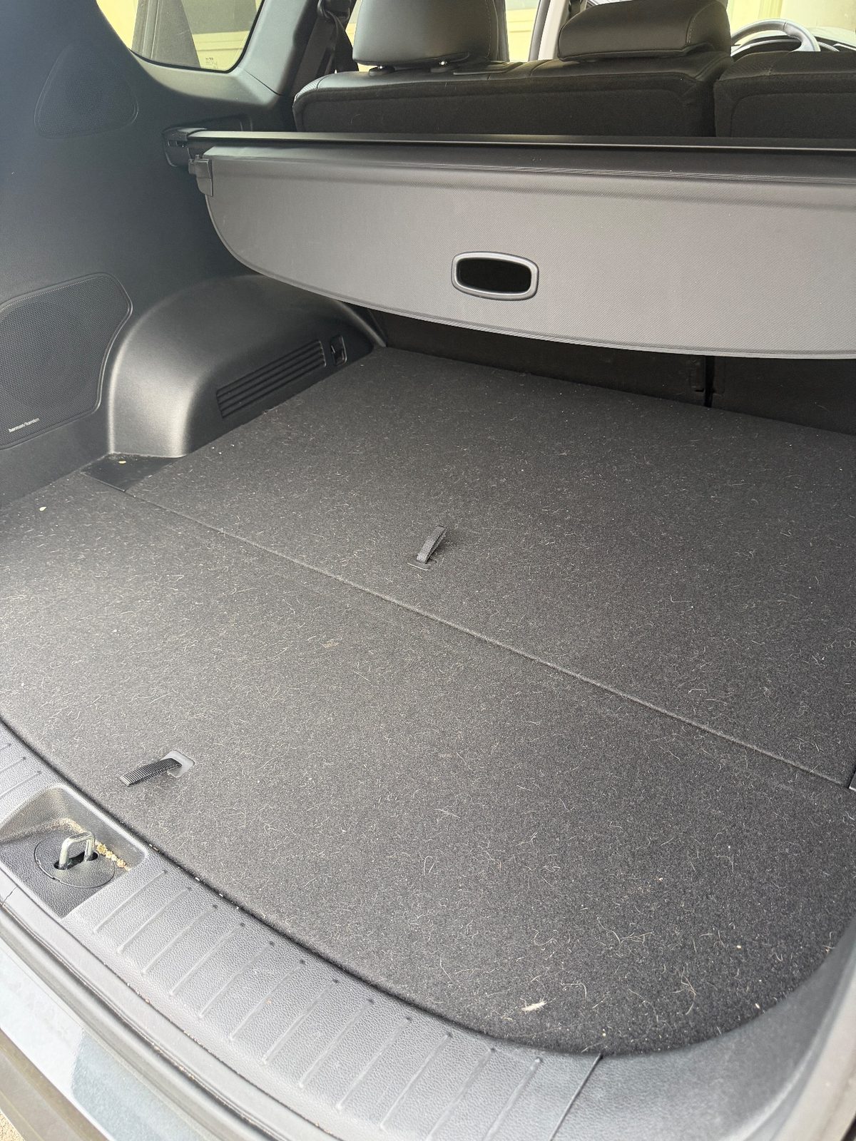 Cargo area carpet of a Hyundai Santa Fe before detailing, with lint and grit