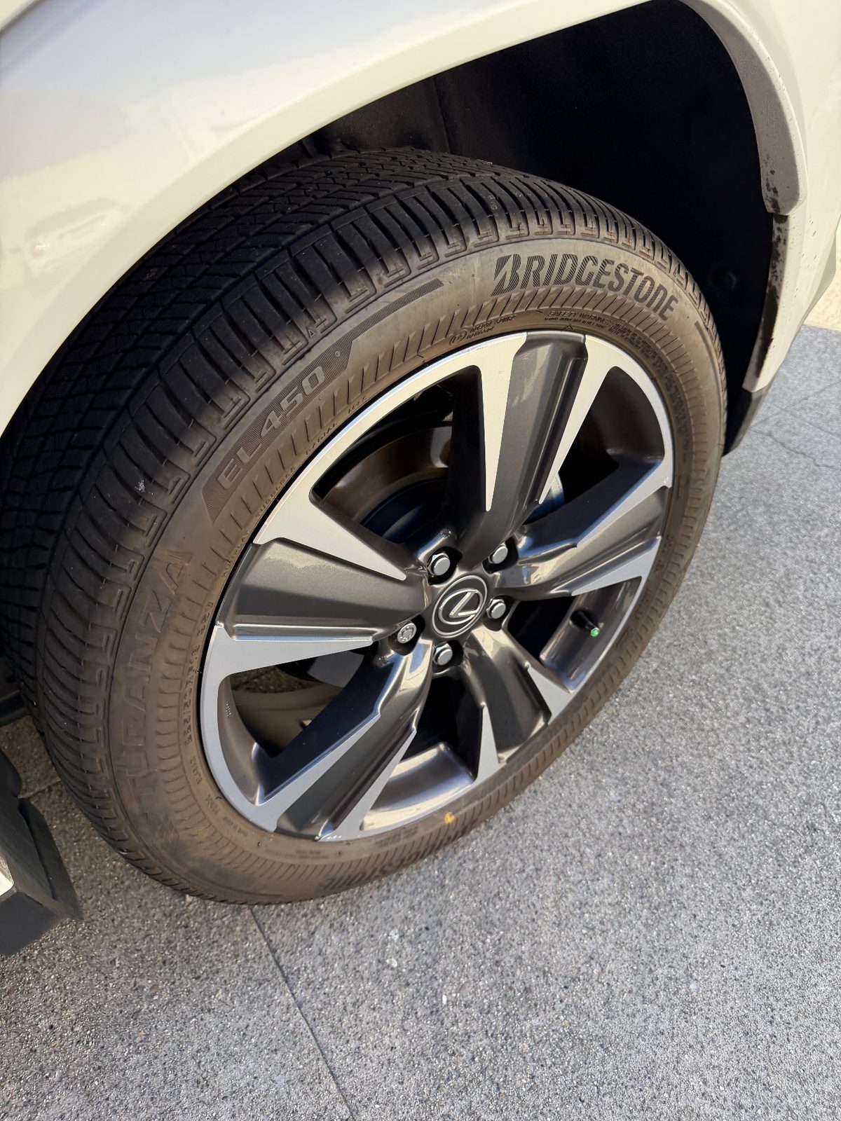 Wheel and tyre of a white Lexus UX before detailing with a grimy sidewall