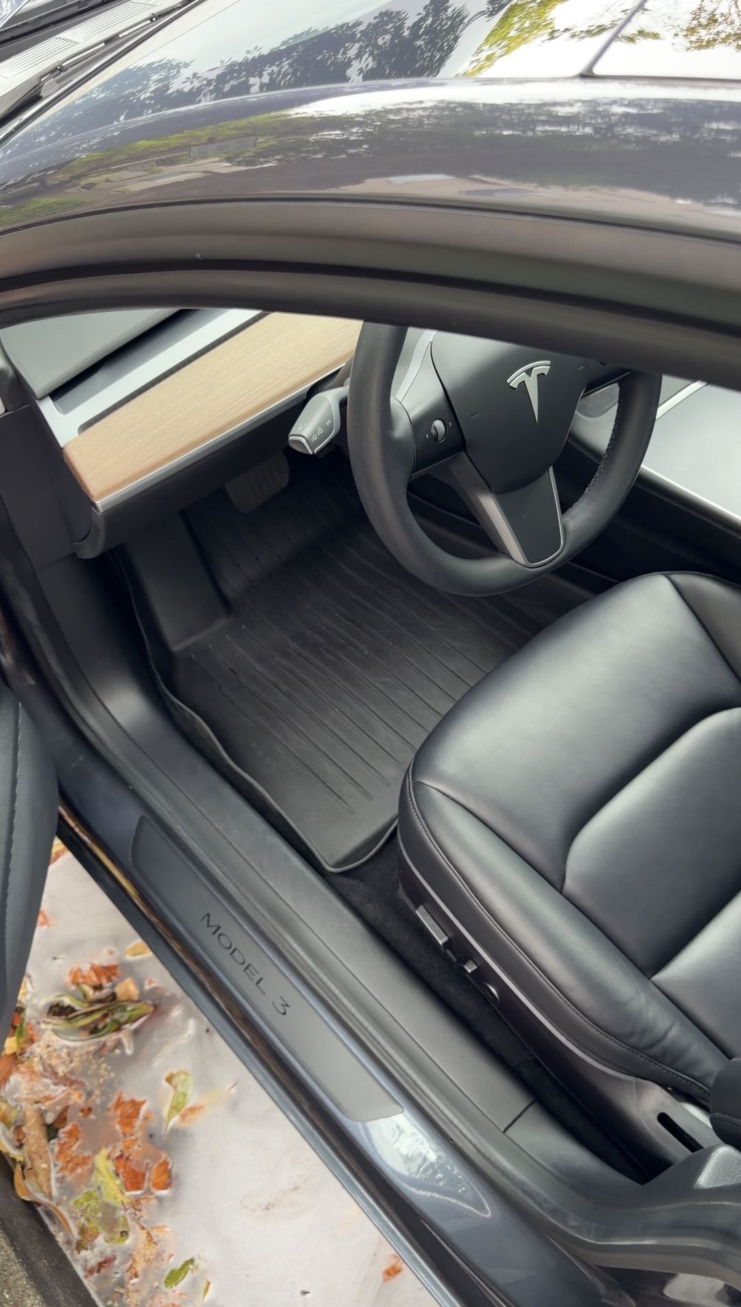 Tesla Model 3 driver footwell after cleaning, seen from the open door above the MODEL 3 sill