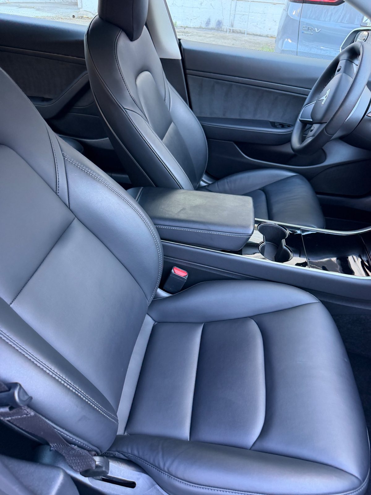 Passenger seat of a white Tesla Model 3 after detailing, clean leather