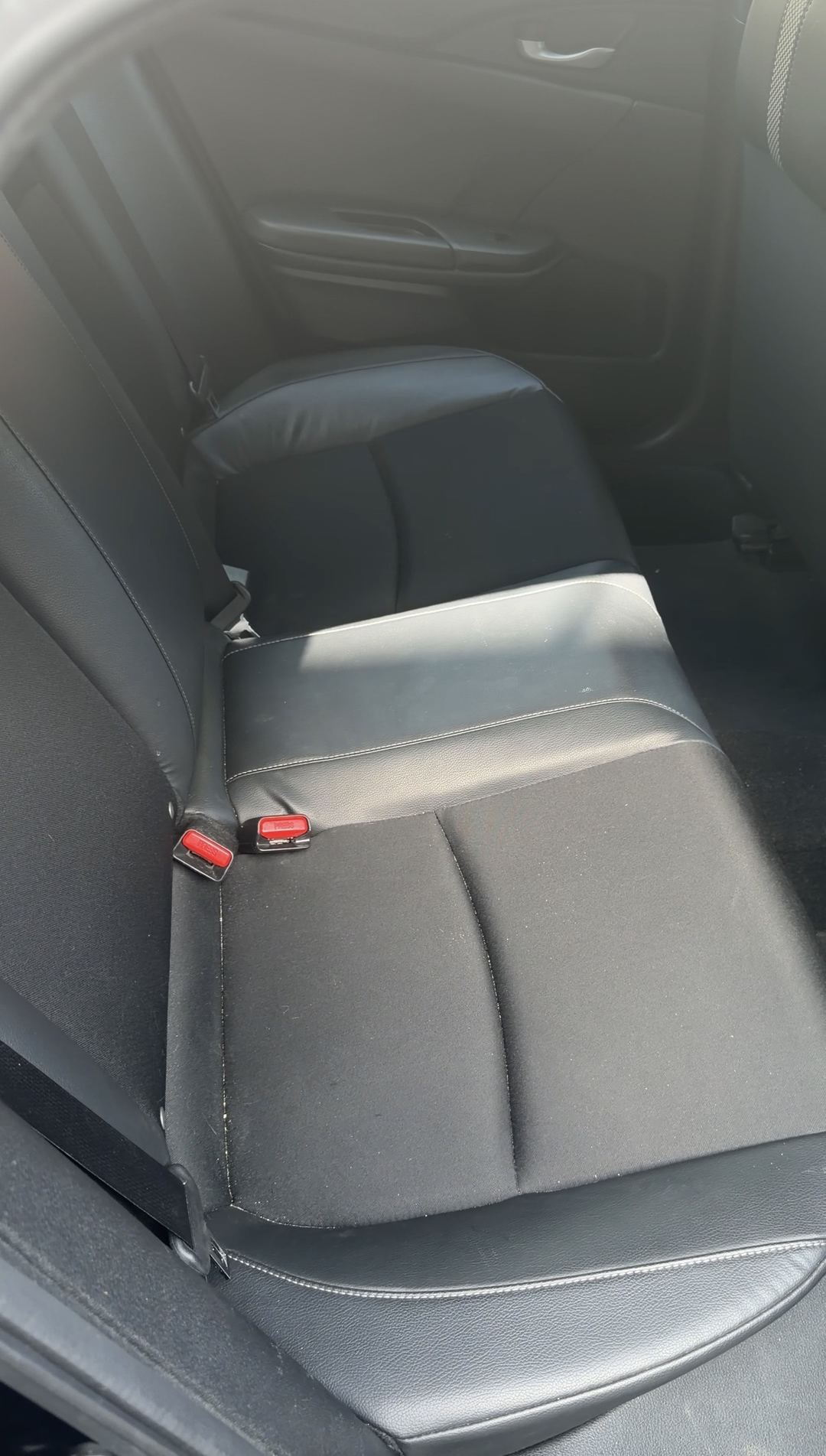 Dusty rear bench seat of a Honda Civic before the interior detail