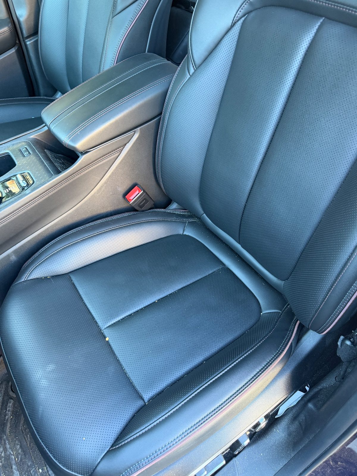 Passenger leather seat of a Jeep Wagoneer S before detailing, with crumbs on the cushion