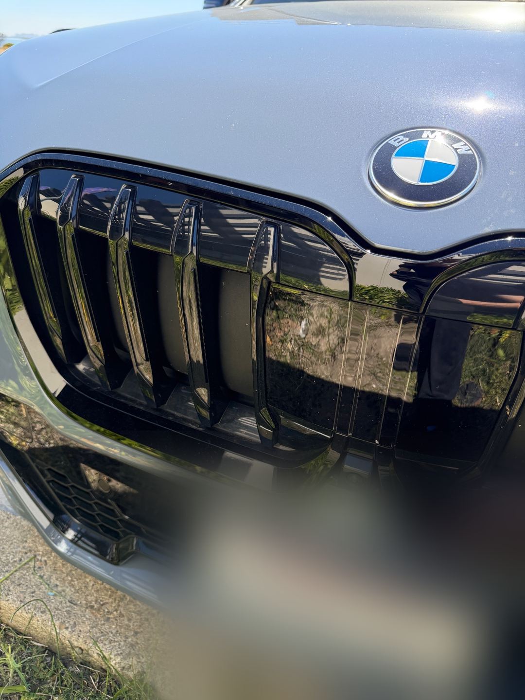 Front grille of a grey BMW X1 before washing