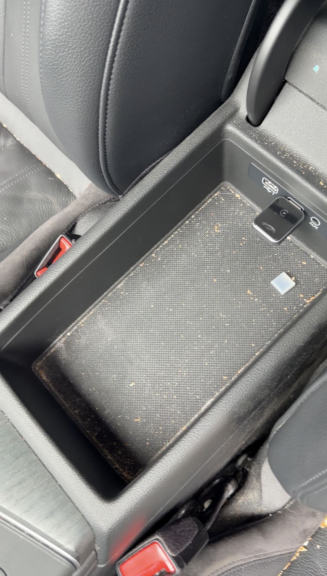 Crumbs and grit in the rubber liner of an Audi A4 centre armrest storage bin