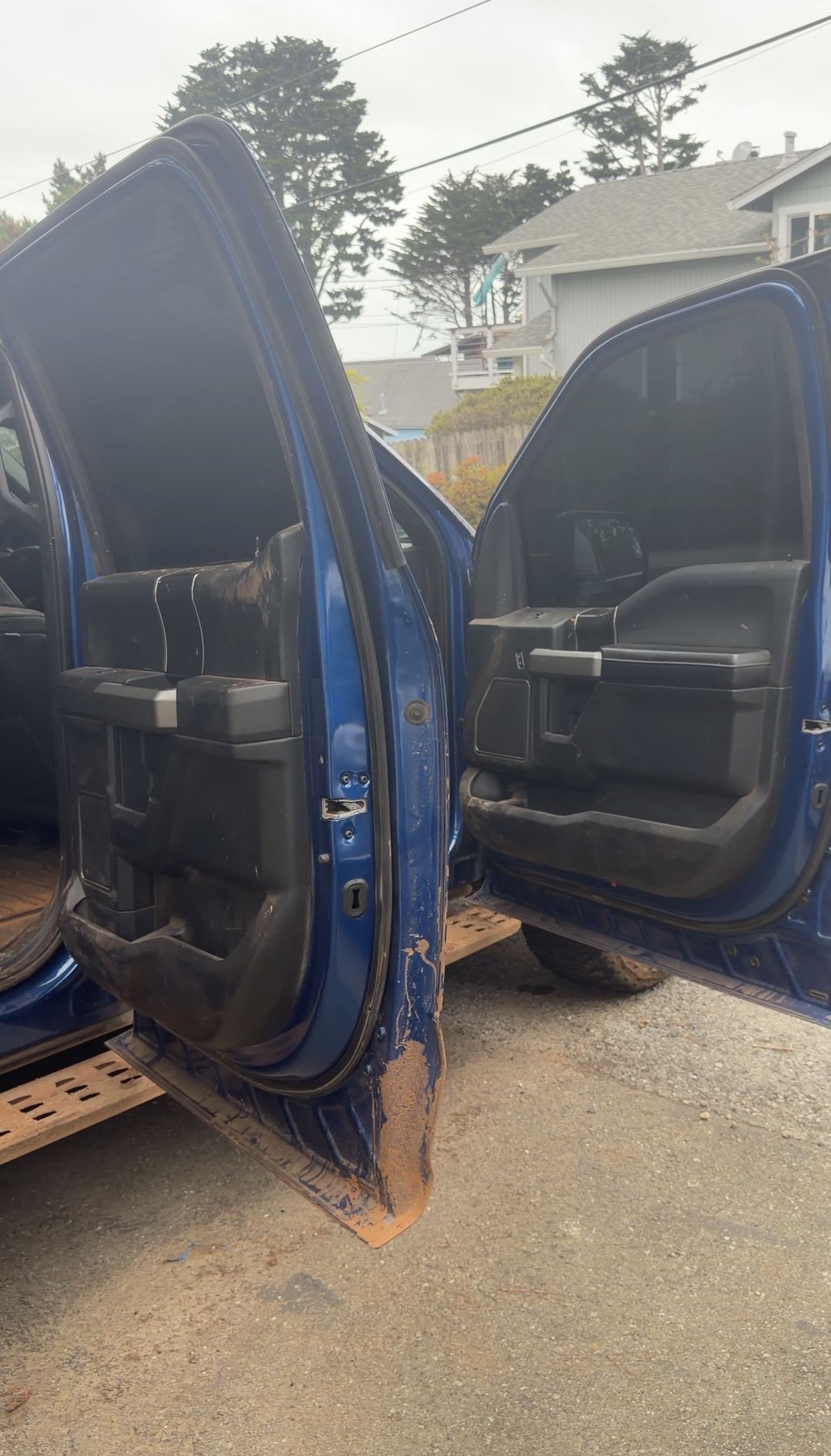 Open doors of a Ford F-150 Raptor showing mud caked in the jambs before a detail