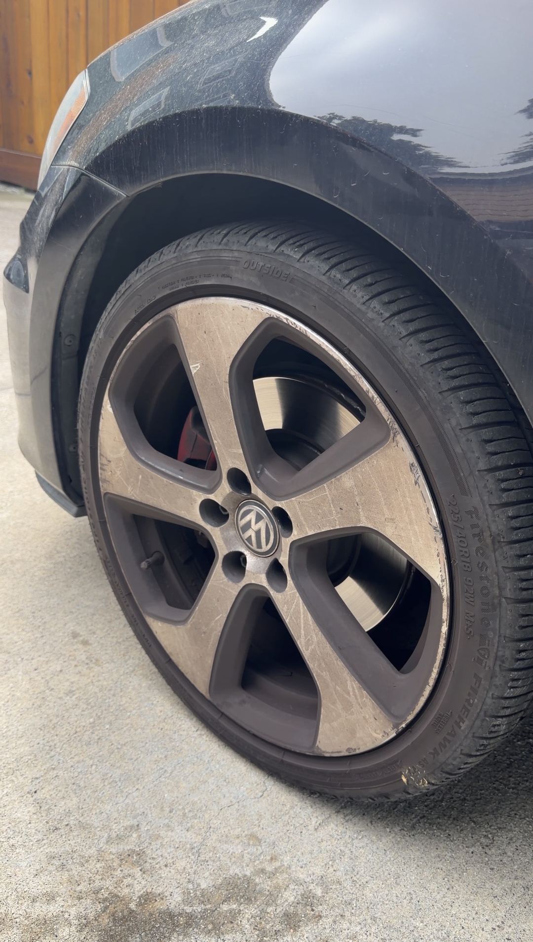 Front-left wheel of a black VW GTI covered in brake dust before cleaning