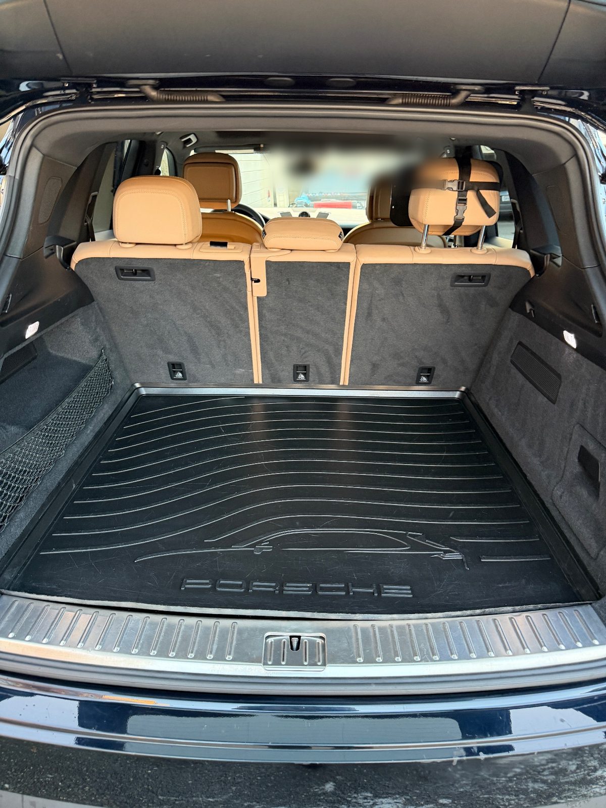 Clean cargo area of a Porsche Cayenne after detailing, rubber mat and sill plate spotless