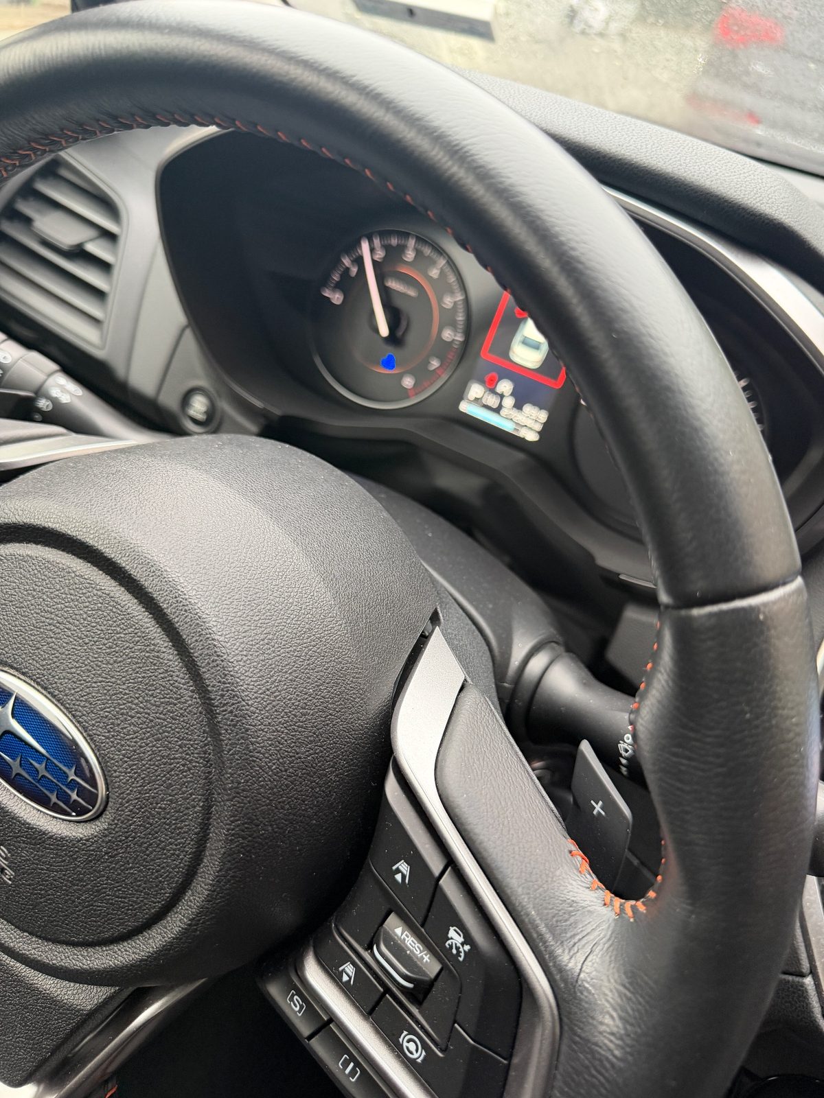 Dusty steering wheel and gauge cluster in a Subaru Crosstrek before cleaning