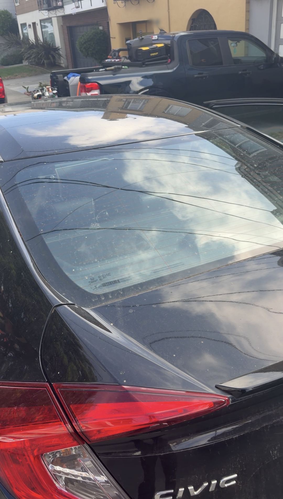 Dust spots on the rear glass and trunk of a Honda Civic before washing