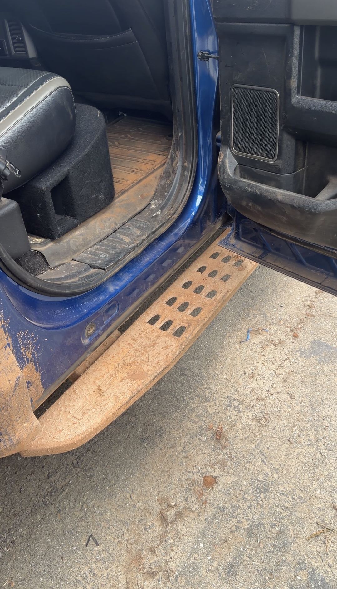 Running board of a Ford F-150 Raptor coated in dried mud before cleaning