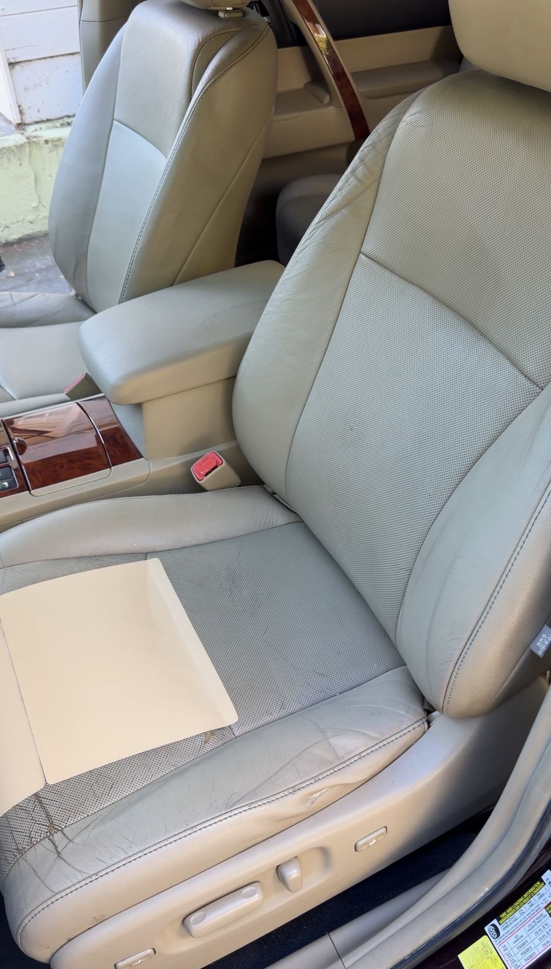 Tan leather driver seat of a Toyota Highlander with a flat card resting on the cushion