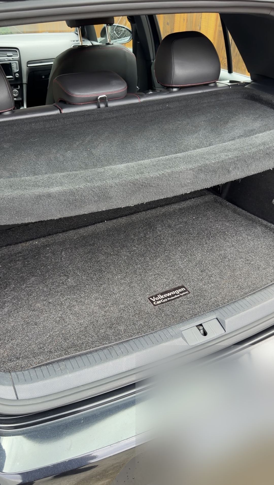 Trunk of a black VW GTI after cleaning, carpet clear of debris