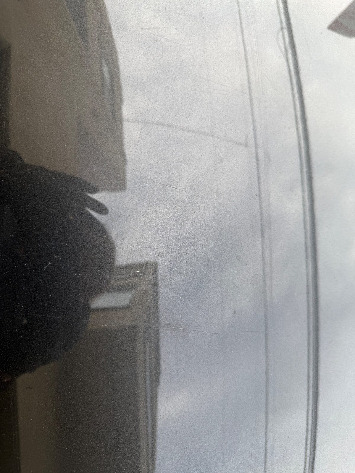 Close-up of faint swirl marks and hairline scratches on the hood paint of a Hyundai Santa Fe before detailing