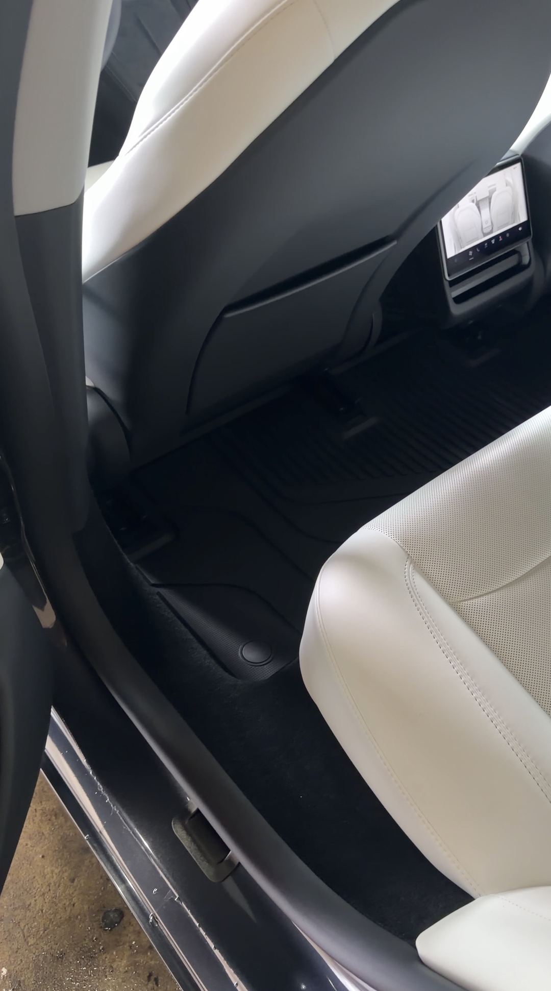Cleaned rear footwell and cream leather rear seat of a Tesla Model 3 after detailing