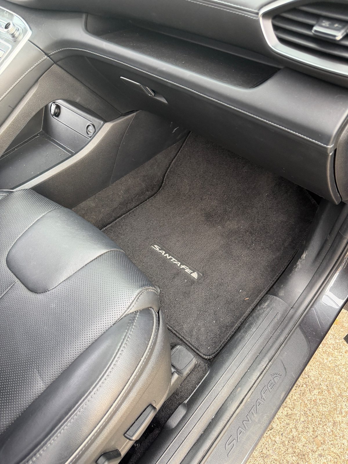 Front passenger footwell mat of a Hyundai Santa Fe before detailing, with lint and crumbs