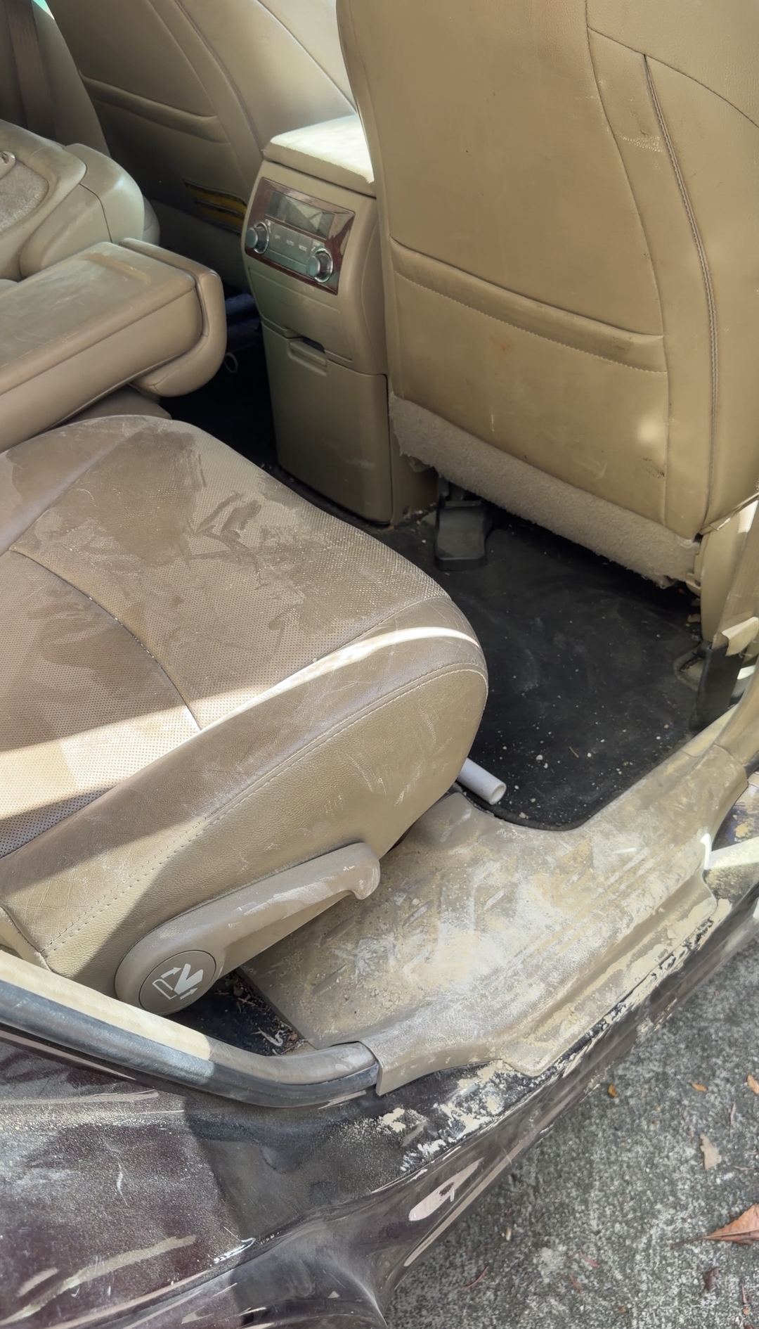 Second-row seat and door sill of a Toyota Highlander caked in pale dust