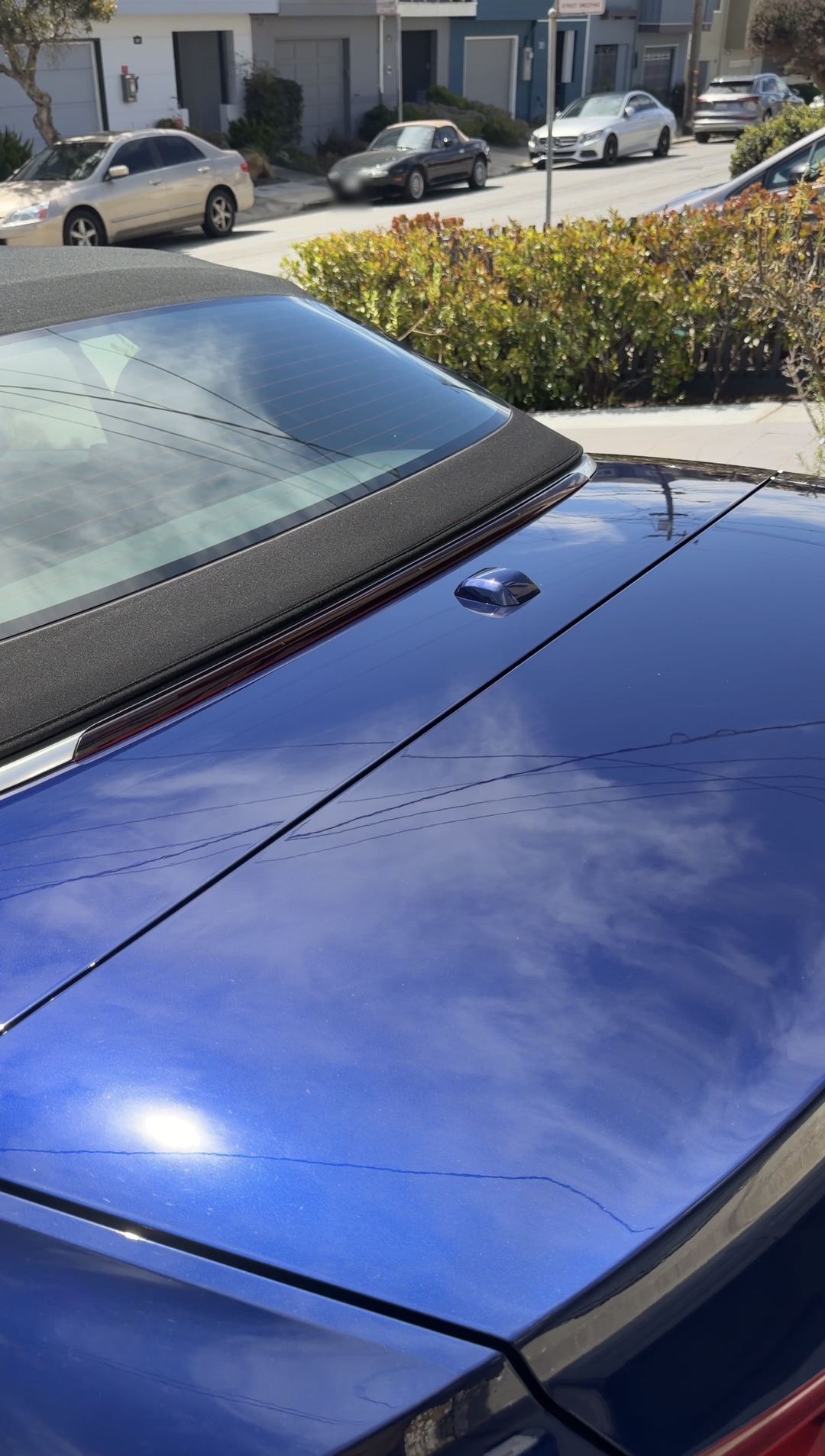 Clean blue decklid of an Audi S5 Cabriolet reflecting the sky below the soft top