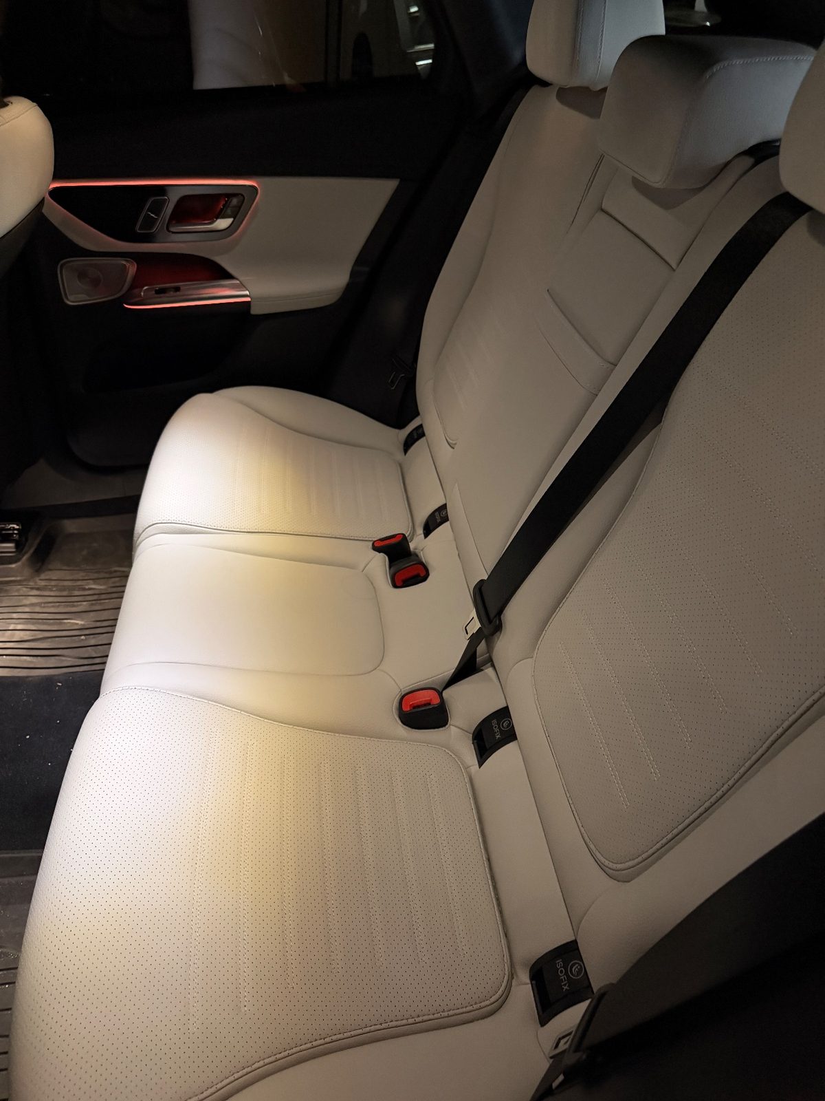 Rear bench seat of a white Mercedes GLC before cleaning, cream leather dull with faint dust